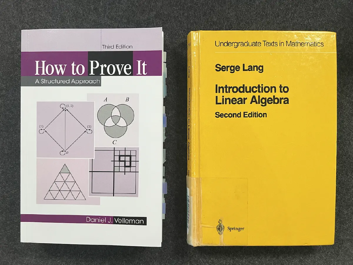 The two books on my desk: How to Prove It by Velleman and Introduction to Linear Algebra by Lang